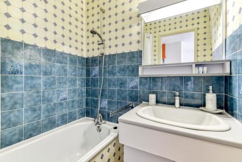 bagno piastrellato blu con vasca e lavandino di Studio cabine Viktoria a Gruissan