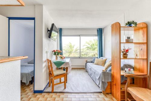 un soggiorno con un divano e un tavolo di Studio cabine Viktoria a Gruissan