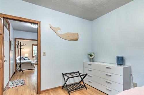 a bedroom with a bed and a dresser and a mirror at Walk to Beach and Main Street Hyannis Cottage in Barnstable