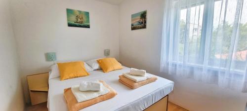 a bedroom with a white bed with towels on it at Apartments Anica Beber in Borovići