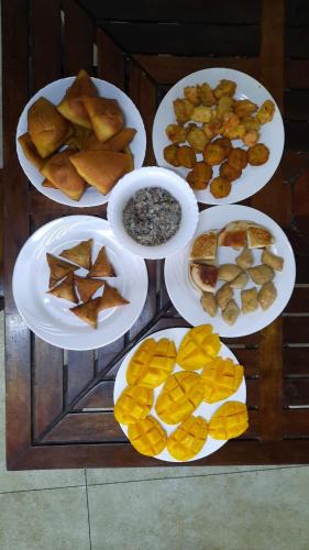 a table with plates of different types of food at Kenyan House Malindi in Malindi