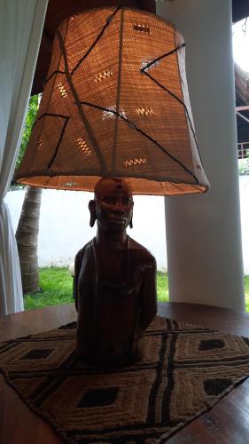 a statue of a person holding a umbrella at Kenyan House Malindi in Malindi