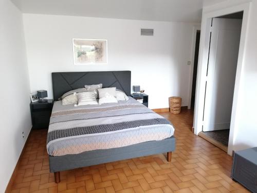 a bedroom with a bed in a white room at Au chant des oiseaux in Hennecourt