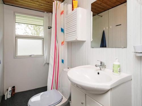 łazienka z umywalką, toaletą i oknem w obiekcie Holiday Home Foldenvej II w mieście Jerup