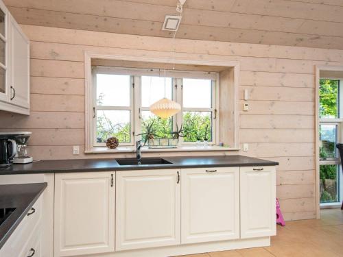 una cucina con armadietti bianchi e una finestra di 8 person holiday home in B rkop a Børkop