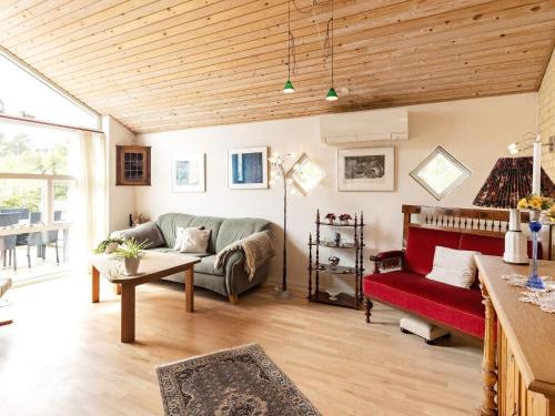 Ålbækにある5 person holiday home in lb kのリビングルーム(ソファ、赤い椅子付)