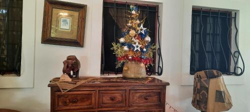 a table with a christmas tree on top of a dresser at Kenyan House Malindi in Malindi
