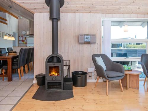 a fireplace in a living room with a chair and a stove at 6 person holiday home in Hemmet in Hemmet