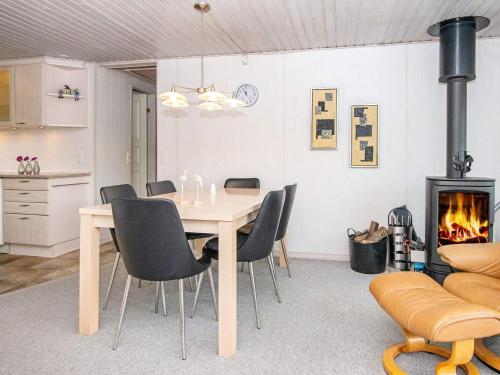 a dining room with a table and chairs and a fireplace at 6 person holiday home in Hemmet in Falen