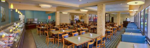 a restaurant with tables and chairs in a cafeteria at Rosen Inn at Pointe Orlando in Orlando
