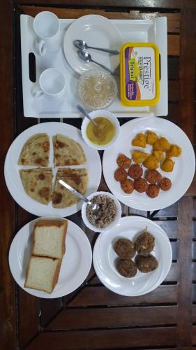 a table with several plates of food on it at Kenyan House Malindi in Malindi