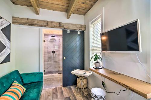 a living room with a television and a green couch at Modern Starkville Tiny Home Near Dining and MSU in Starkville