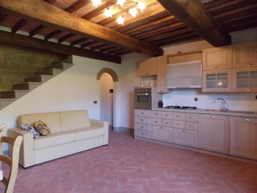 a living room with a couch and a kitchen at Tenuta Poggio Marino in Dicomano