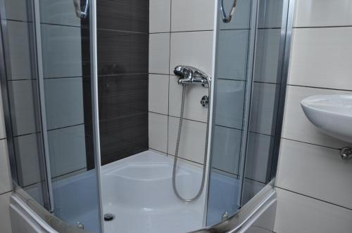 a shower with a glass door next to a sink at Rooms Turist in Vladičin Han