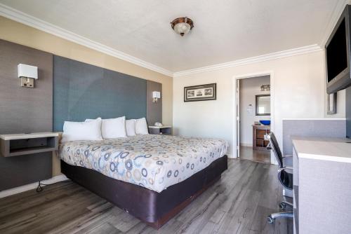 a hotel room with a bed and a flat screen tv at Solaire Inn & Suites in Santa Maria