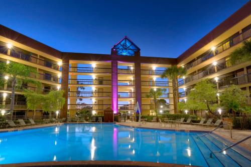 a hotel with a swimming pool at night at Rosen Inn Lake Buena Vista in Orlando