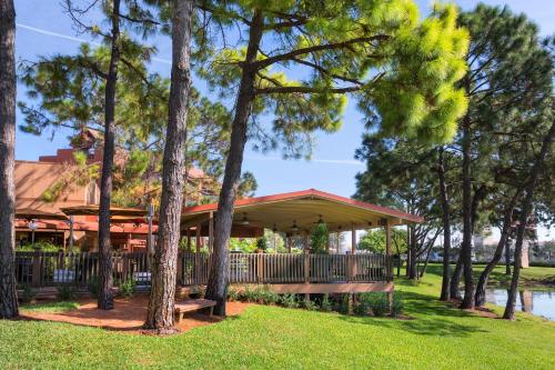 a pavilion with a bench in a park with trees at Rosen Inn Lake Buena Vista in Orlando