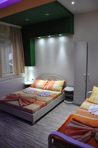 a bedroom with two beds and a green ceiling at Rooms Turist in Vladičin Han