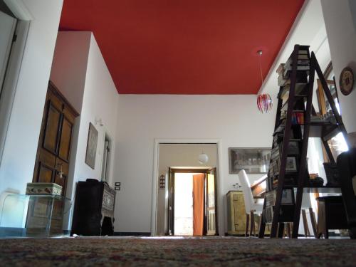 sala de estar con techo rojo y escalera en B&B A Casa Tua, en Asís