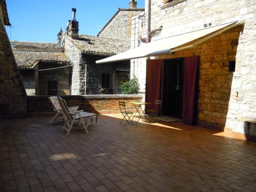 a patio with chairs and an awning next to a building at B&B A Casa Tua in Assisi