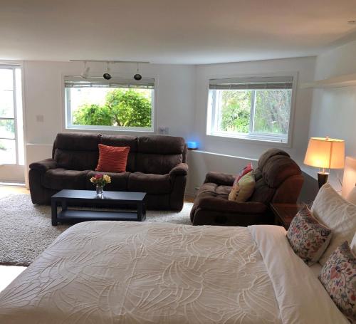 uma sala de estar com uma cama e um sofá em one bedroom suite near Hillside mall em Victoria
