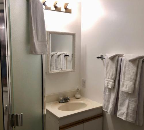 uma casa de banho com lavatório, espelho e toalhas em one bedroom suite near Hillside mall em Victoria