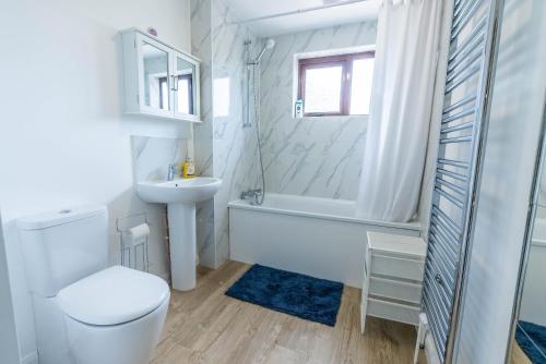 biała łazienka z toaletą i umywalką w obiekcie 4 en-suite bedroom house with free parking Aylesbury w mieście Buckinghamshire