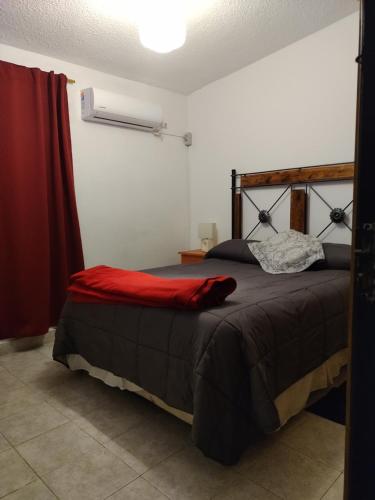 a bedroom with a bed with a red blanket at Residencia Don Roque in Santa Rosa