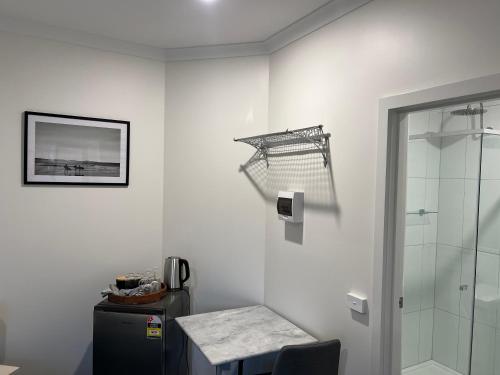 a bathroom with a shower and a table and a glass door at BENDIGO BOTANIC MOTEL- with KING BEDS-REFURBISHED 2022 in Bendigo