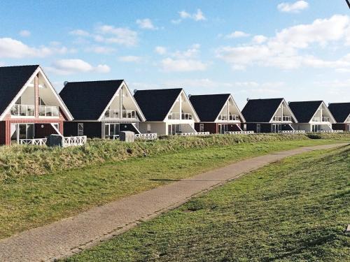 a row of houses in a field with a dirt road at 4 person holiday home in Wendtorf in Wendtorf