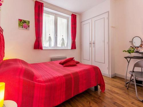 ein rotes Bett in einem Schlafzimmer mit roten Vorhängen in der Unterkunft Gîte Blain, 2 pièces, 2 personnes - FR-1-306-1007 in Blain