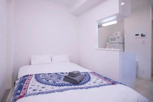 a white bedroom with two beds with towels on it at japan house sugamo in Tokyo