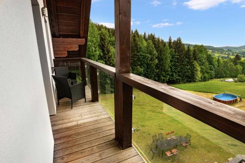 a wooden balcony with a view of a yard at Rezidence Rokytnice in Rokytnice nad Jizerou