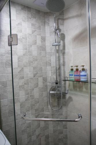 a shower with a glass door with two bottles of cleaner at Hongdae Residence-2 1min from Hongik Uni station Exit #1 in Seoul
