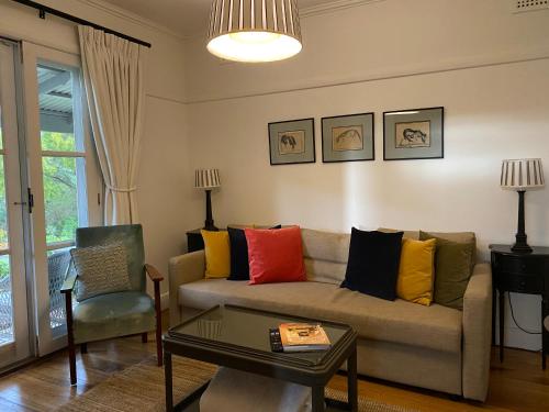 a living room with a couch with colorful pillows at Aashay Country Stay in Fish Creek