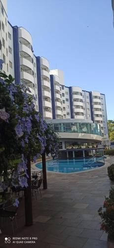 a large apartment building with flowers in front of it at Apart no Águas da Serra - 115B in Rio Quente
