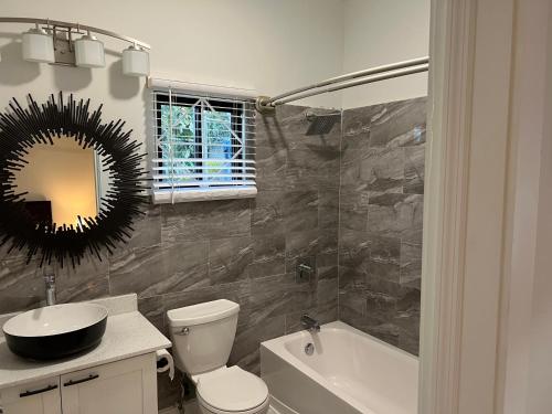 a bathroom with a toilet and a sink and a mirror at Luxury Studio Rooftop Pool n View unit #4 in Falmouth
