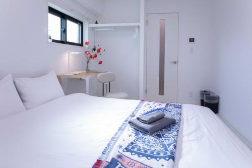 a bedroom with a white bed with a pillow on it at japan house sugamo in Tokyo
