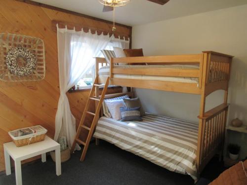 een slaapkamer met twee stapelbedden en een tafel bij Lazy Pines in Sugarloaf