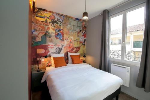 1 dormitorio con 1 cama blanca grande con almohadas de color naranja en L'Industriel, T2 hypercentre chic et cosy, Wifi par SOVALFI en Saint-Étienne