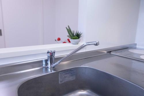 a stainless steel sink with a sign on it at japan house sugamo in Tokyo