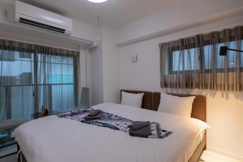 1 Schlafzimmer mit einem großen weißen Bett und 2 Fenstern in der Unterkunft japan house sugamo in Tokio