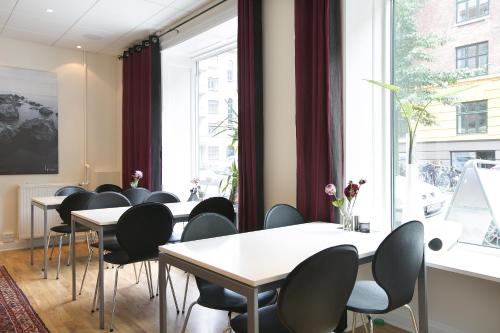 a room with tables and chairs and a large window at Hotel Copenhagen in Copenhagen