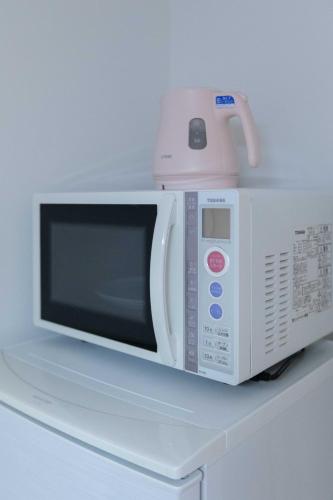 a white microwave oven sitting on top of a counter at japan house sugamo in Tokyo