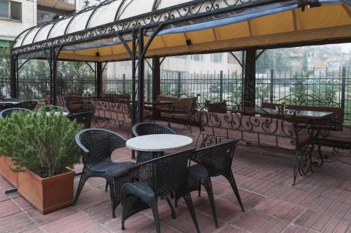 a patio with tables and chairs on a balcony at Family Hotel Pautalia in Sandanski