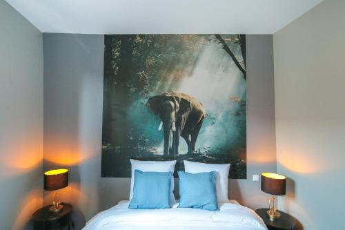 une chambre avec une peinture d'éléphant sur le mur dans l'établissement L'Eléphant, T2 hypercentre chic et cosy, Wifi par SOVALFI, à Saint-Étienne