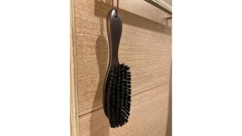 a black brush is hanging on a door at Via Inn Higashiginza in Tokyo
