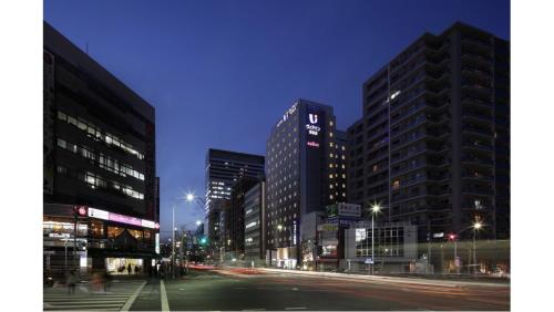 a city street at night with tall buildings at Via Inn Higashiginza in Tokyo