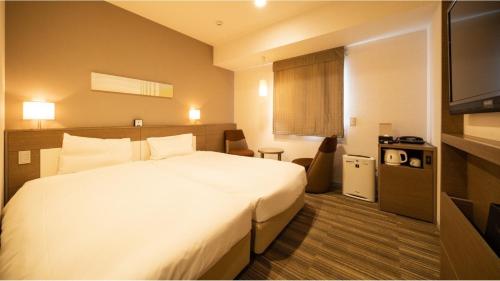 a hotel room with a bed and a flat screen tv at Via Inn Higashiginza in Tokyo