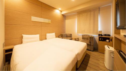 a bedroom with a large white bed in a room at Via Inn Higashiginza in Tokyo
